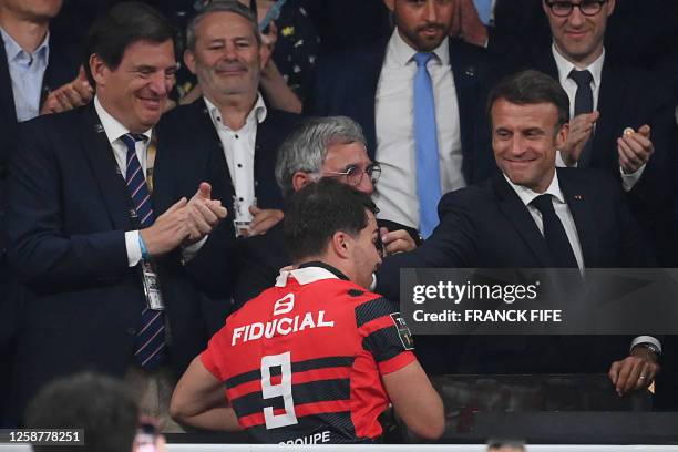 Toulouse's French scrum-half Antoine Dupont is congratulated by French President Emmanuel Macron after they winning the French Top14 rugby union...