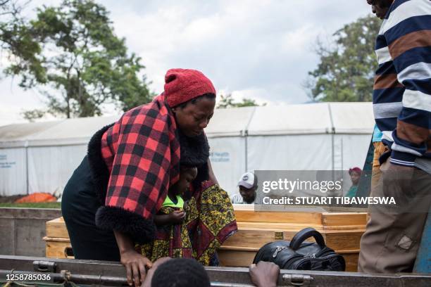 The relative of a victim of the Mpondwe Lhubiriha Secondary School mourns as she leans towards a casket outside the Bwera General Hospital Mortuary,...