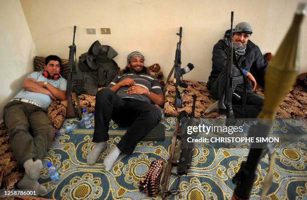 Libyan rebels rest inside a house in Al-Ghiran near Misrata airport on May 1 hours before the house was hit by a mortar shell fired by Moamer...