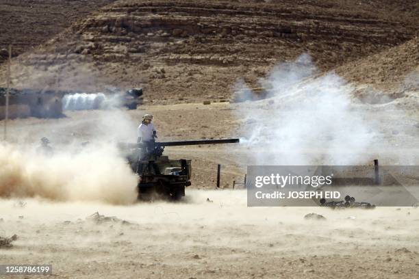 Libyan National Transitional Council fighters fire their small caliber canon positioned on the frontline with the city of Bani Walid on September 13,...