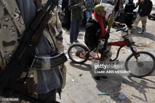 Libyan rebels wait at a checkpoint in Brega, 240 kms south of Benghazi, on March 30, 2011 as outgunned rebels fled the key oil town of Ras Lanuf...