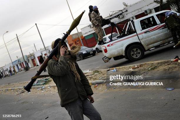 Libyan rebel carries and rocket-propelled grenade launcher on March 13, 2011 before dozens opposition fighters were pulling out of the eastern town...