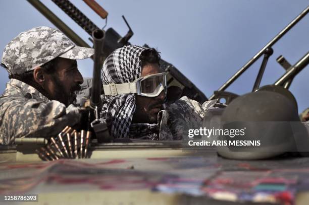 Libyan rebels hold their positions on the outskirts of the town of Bin Jawad on March 27, 2011 as rebels pushed westwards in hot pursuit of Moamer...