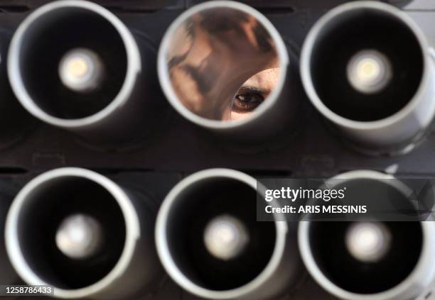 Libyan rebel looks though a multiple rocket launcher on the outskirts of the town of Bin Jawad on March 27, 2011 as rebels pushed westwards in hot...