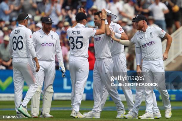 England's James Anderson celebrates with teammates after bowling Australia's wicket keeper Alex Carey on day three of the first Ashes cricket Test...