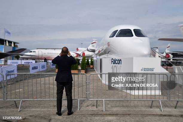 Visitor takes a picture next to the business jet Dassault Falcon 10X during the International Paris Air Show at the ParisLe Bourget Airport on June...
