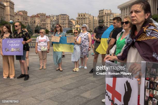 Relatives, friends and members of the public hold Ukrainian flags and placards as they attend a rally in support of Ukrainian prisoners of war...