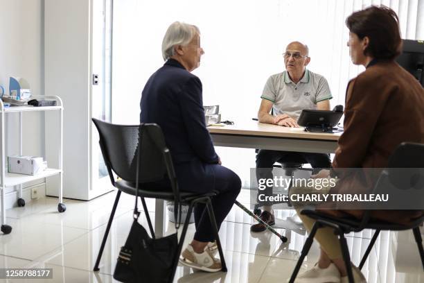 General practitioner Pierre Le Tinnier a doctor who was retired and has returned to work, speaks with patients in his office during a medical...