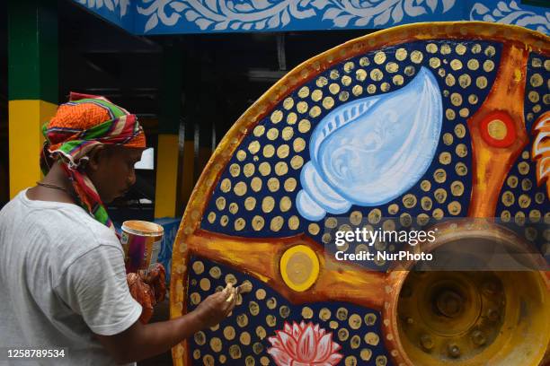 An artist painting on a wheel of a chariot of lord Jagannath ahead of the Rath yatra festival in Kolkata, India on 18 June 2023.