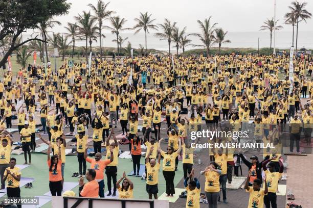Hundreds of yoga enthusiasts take part in a mass yoga session at the amphitheatre lawns at North Beach on June 18, 2023 in Durban, South Africa,...