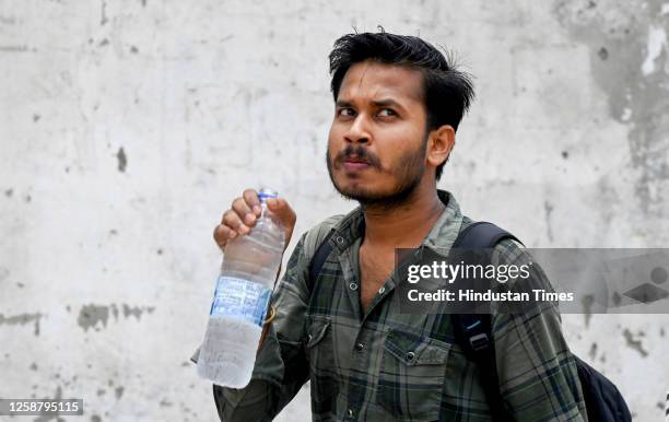 Commuters quenches thirst by drinking water on a hot summer day in sector 52, on June 18, 2023 in Noida, India.