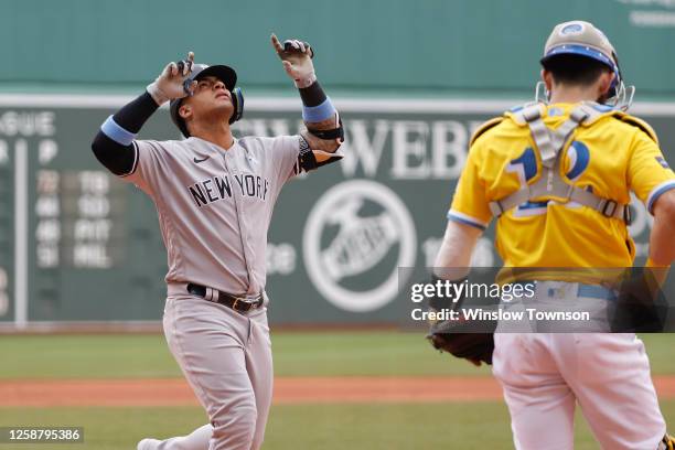 Gleyber Torres of the New York Yankees points skyward after his two-run home run as catcher Connor Wong of the Boston Red Sox hangs his head during...