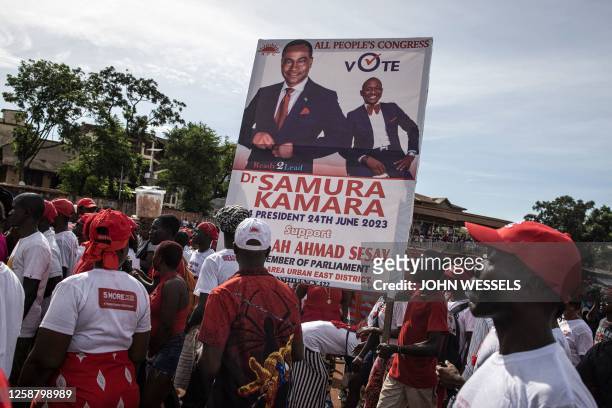 Supporters of opposition party, All peoples Congress, carry a poster with the portrait of their leader, Samura Kamara, as they gather for their final...