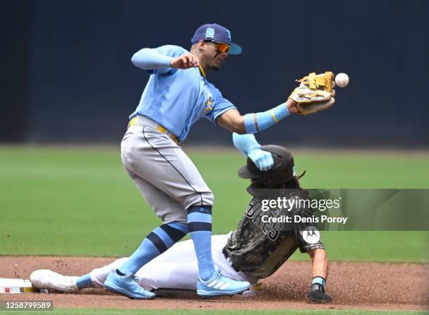 Wander Franco of the Tampa Bay Rays drop the ball as Fernando Tatis Jr. #23 of the San Diego Padres steals second base during the first inning of a...