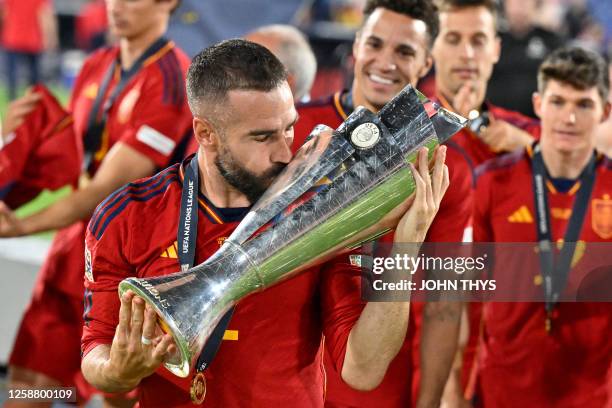 Spain's defender Dani Carvajal kisses the UEFA Nations League cup as he celebrates after winning the penalty shootouts and the UEFA Nations League...