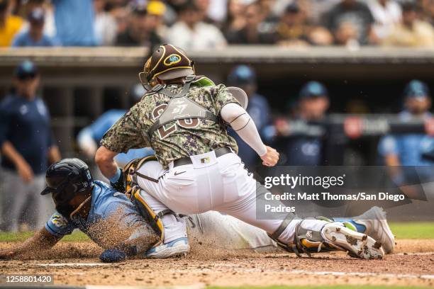 Austin Nola of the San Diego Padres tags out a runner at home plate in the eighth inning against the Tampa Bay Rays on June 18, 2023 at Petco Park in...