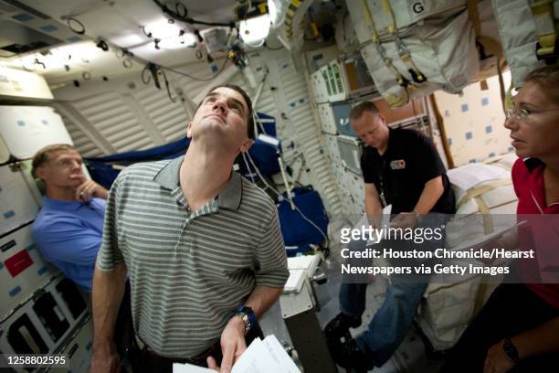 The crew of STS-135, from left, Chris Ferguson, Rex Walheim, Doug Hurley and Sandy Magnus review procedures on the mid-deck of the Crew Compartment...