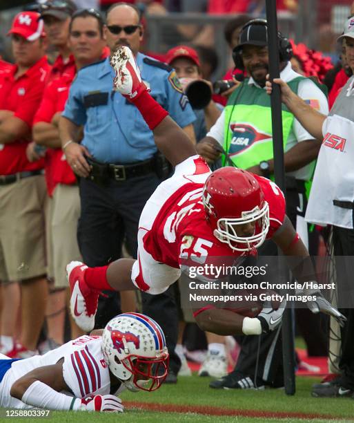 Houston running back Bryce Beall is upended by SMU defensive back Richard Crawford during the first half in an NCAA football game at Robertson...