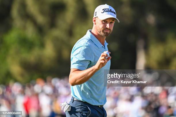 Wyndham Clark waves his ball to fans after making a birdie putt on the 14th hole green during the final round of the 123rd U.S. Open Championship at...