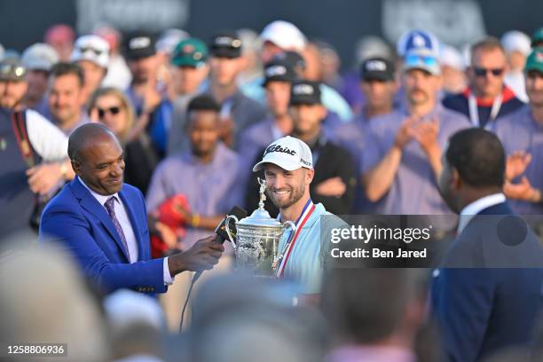 Wyndham Clark holds the trophy on the 18th green after the final round of the 123rd U.S. Open Championship at The Los Angeles Country Club on June...