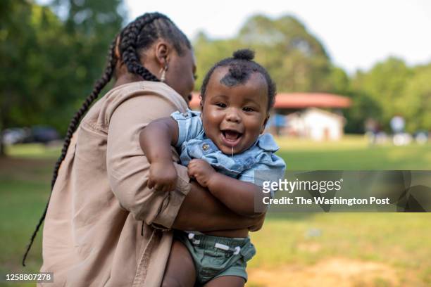 Eight-month-old Ean Hunt reacts while being carried by his mother, MaKayla Walker at Lake Varner Reservoir in Covington, Georgia, June 17, 2023.