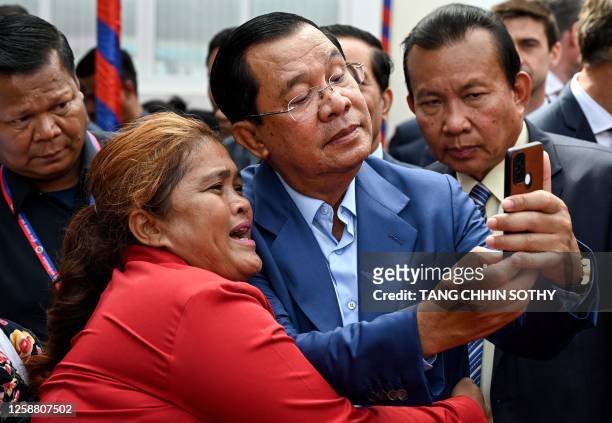Cambodia's Prime Minister Hun Sen takes selfies with a supporter during the inauguration ceremony of the Bakheng-1 water treatment plant in Phnom...