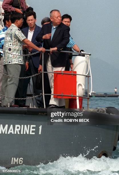 Hong Kong Chief Executive Tung Chee-hwa and three local fishermen survey the area around Hong Kong's Lamma Island which has been wiped out by red...