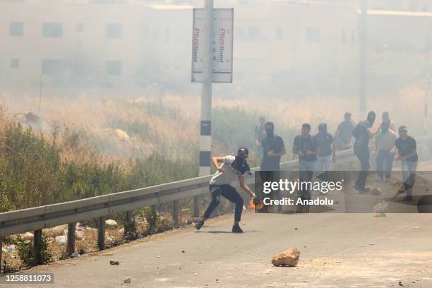 Protester throws a molotov cocktail in response to Israeli forces' intervention with plastic bullets and tear gas bombs during a protest as Israeli...
