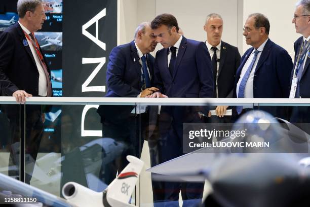 French President Emmanuel Macron speaks with Dassault Aviation's CEO Eric Trappier , in front of a model of the French multirole fighter aircraft...