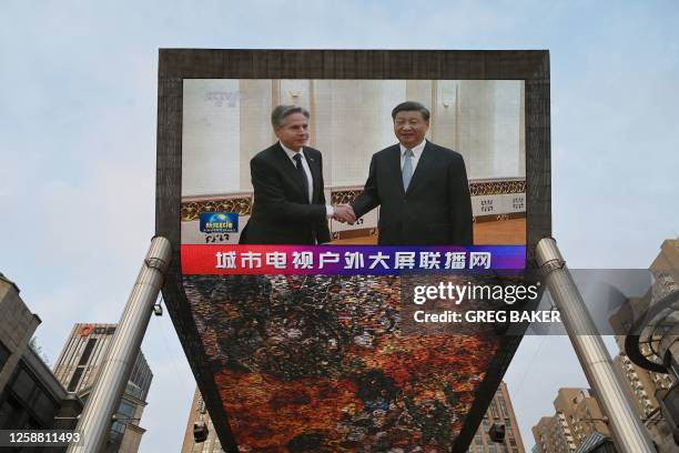 China Central Television news broadcast shows footage of US Secretary of State Antony Blinken meeting with China's President Xi Jinping, on a giant...