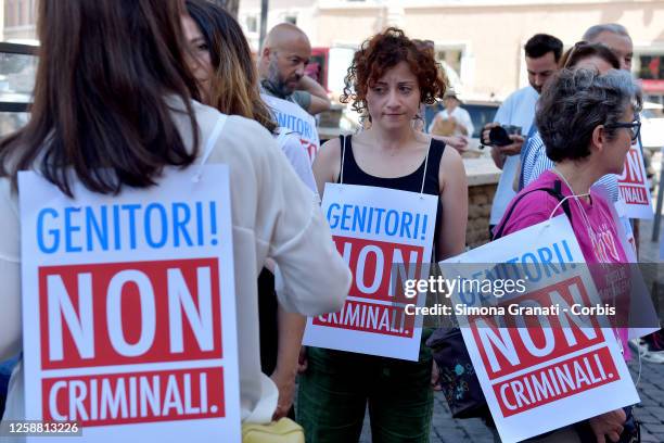 People holding signs reading: "Parents, Not Criminals" participate in demonstration against the criminalization of Gestation for Others , on June 19,...