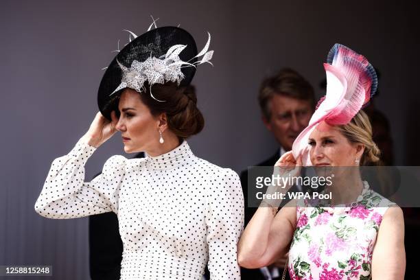 Catherine, Princess of Wales and Sophie, Duchess of Edinburgh hold their hats as they arrive at St George's Chapel to attend the Order Of The Garter...