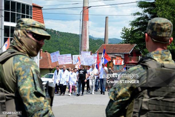 Austrian NATO peacekeepers stand as employees of the local hospital lead a protest march of ethnic Serbs, from the flashpoint city of Mitrovica...