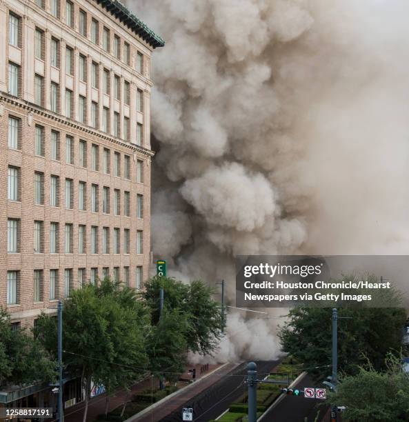 Series of explosive charges brings down the landmark former Macy's department store building in downtown Houston on Sunday, Sept. 22, 2013. Many...