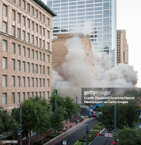 Series of explosive charges brings down the landmark former Macy's department store building in downtown Houston on Sunday, Sept. 22, 2013. Many...