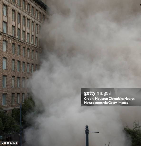 Series of explosive charges brings down the landmark former Macy's department store building in downtown Houston on Sunday, Sept. 22, 2013. Many...