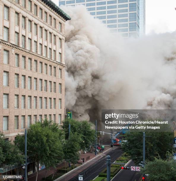 Series of explosive charges brings down the landmark former Macy's department store building in downtown Houston on Sunday, Sept. 22, 2013. Many...