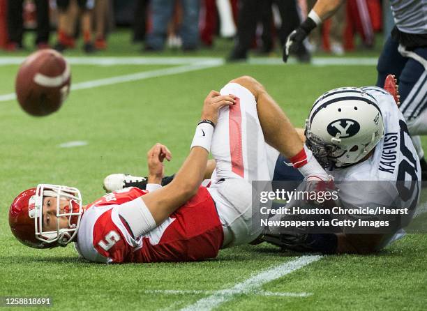 Houston quarterback John O'Korn watches the ball bounce away as he tries to lateral while being tackled by Brigham Young defensive lineman Bronson...