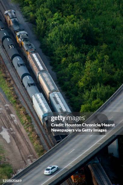 Cars on the Hardy Tollway pass over a train seen in an aerial view on Wednesday, Aug. 20 in Houston. City: Houston Location: Northline GPS:...