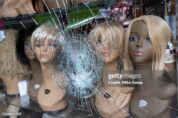 Broken shop window of a beauty products and wig store featuring hair pieces on multicultural mannequins on 6th June 2023 in Halifax, United Kingdom....