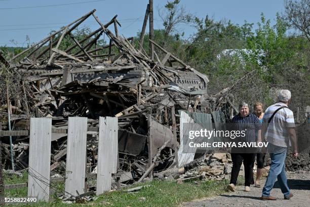 Residents walk past a house destroyed by an earlier Russian missile attack, in the town of Kramatorsk, Donetsk Region, on June 19 amid the Russian...