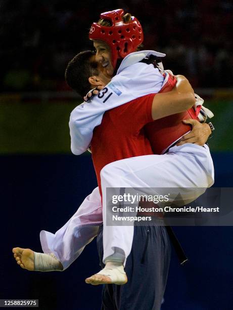 Diana Lopez of Sugar Land, Texas leaps into the arms of her coach and brother Jean Lopez after winning her 57kg taekwondo bronze medal match against...