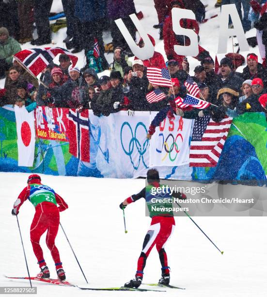 Todd Lodwick of the USA leads David Kreiner of Austria to the cheers of the crowd on the second leg in the cross country relay of the Nordic Combined...