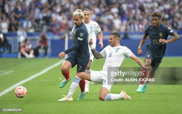 France's forward Antoine Griezmann fights for the ball with Greece's midfielder Dimitrios Kourbelis during the UEFA Euro 2024 group B qualification...