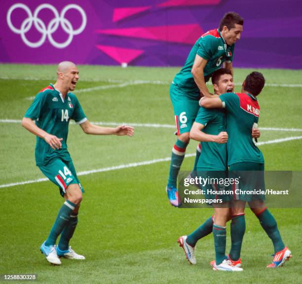 Mexico's Oribe Peralta celebrates with Marco Fabian , Hector Herrera and Jorge Enriquez after he scored a goal in the 75th minute against Brazil in...