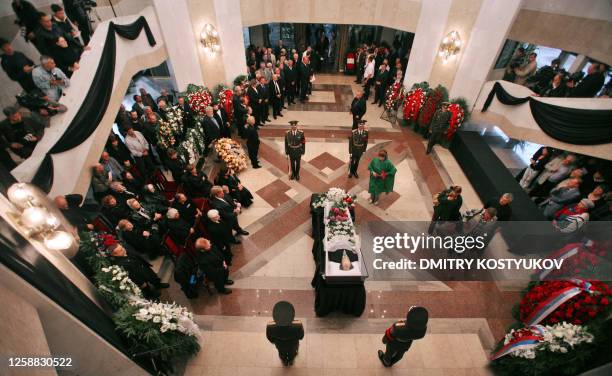 People places flowers at the coffin of Russian author and dissident Alexander Solzhenitsyn during his wake in Moscow on August 5, 2008. Russians paid...