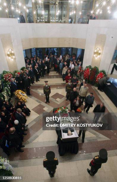 Man places flowers on the coffin of Russian author and dissident Alexander Solzhenitsyn during his wake in Moscow on August 5, 2008. Russians paid...