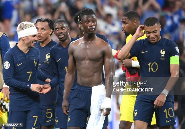 France's forward Antoine Griezmann with a bandage on his head, France's midfielder Eduardo Camavinga, and France's forward Kylian Mbappe celebrate...