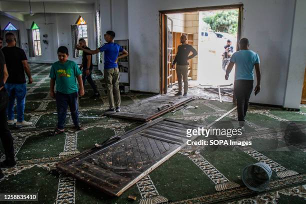Palestinians inspect a mosque which was damaged when Israeli helicopters bombed a site next to it during a raid on the Jenin camp in the northern...