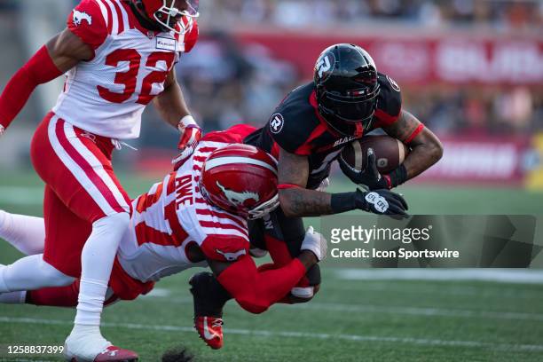 Ottawa Redblacks wide receiver Justin Hardy is tackled by Calgary Stampeders linebacker Micah Awe during Canadian Football League action between the...